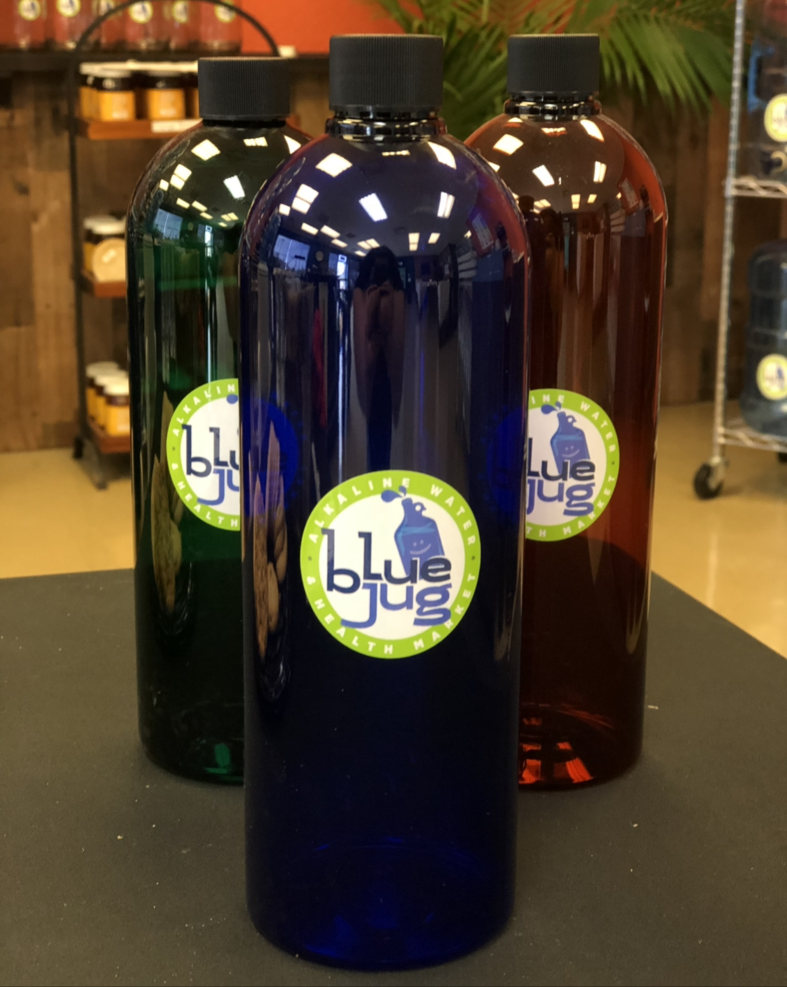 Three colored bottles with Blue Jug labels on display
